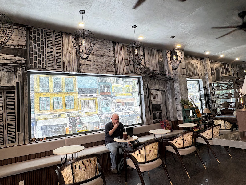 Tables and cane chairs beneath mural-covered café walls